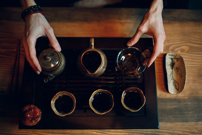 Cropped hand of woman holding coffee on table