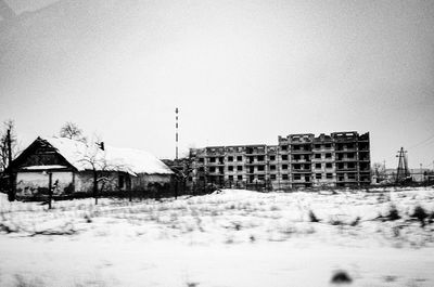 Buildings in city against clear sky during winter