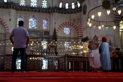 Rear view of people standing at illuminated temple