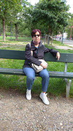 Portrait of man sitting on bench in park