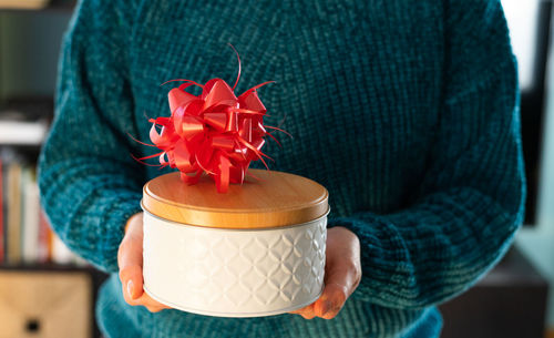 Midsection of woman holding container