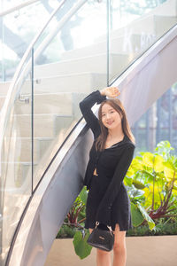 Portrait of young woman standing in city