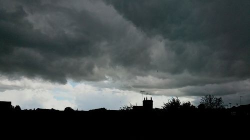 Silhouette of buildings against cloudy sky