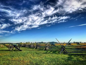 Bicycles on field against blue sky