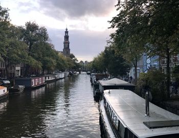 View of river in city against cloudy sky