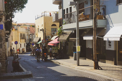 People on street amidst buildings in city