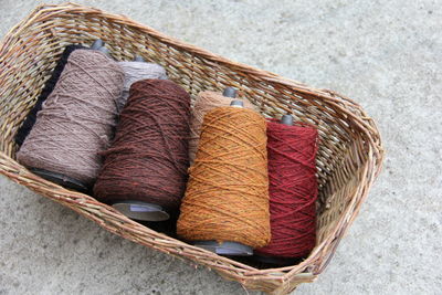 High angle view of colorful thread spools in wicker basket