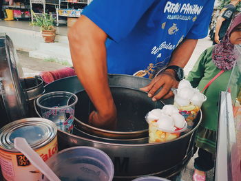 Midsection of man preparing food at market stall