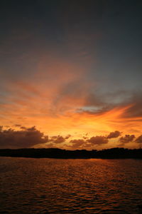 Scenic view of sea against dramatic sky during sunset