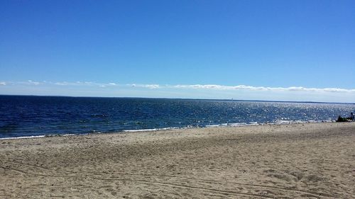 View of calm beach against blue sky