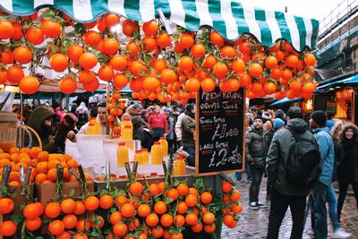 Oranges hanging on market stall in city