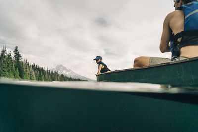 A young girl rides in a canoe with her dad on lost lake in oregon.