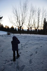 Rear view of man on snow covered landscape