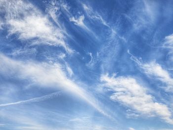 Low angle view of sunlight streaming through clouds