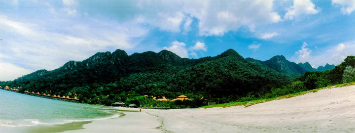 Panoramic shot of calm beach against mountain range
