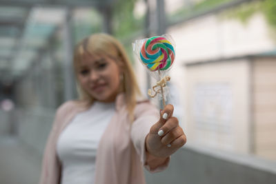 Young woman holding lollipop