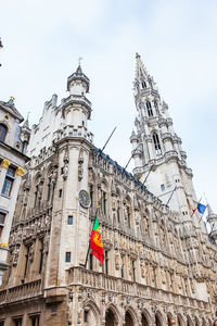 Low angle view of flags on building against sky