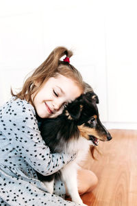 Girl embracing dog at home