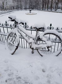Snow covered bicycle on field during winter