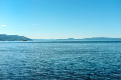 Scenic view of lake against clear blue sky