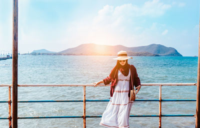 Woman standing on boat in sea against sky