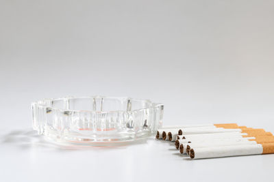 Close-up of glasses on table against white background