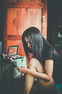 Woman sitting on table at home