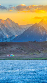 Scenic view of snowcapped mountains against sky during sunset