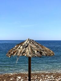 Lifeguard hut on beach against clear blue sky