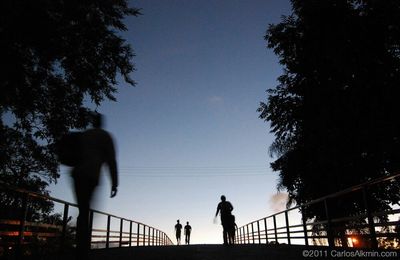 Low angle view of silhouette people walking on bridge