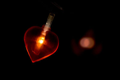 Close-up of illuminated lighting equipment against black background