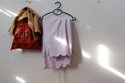 Close-up of clothes hanging on white wall