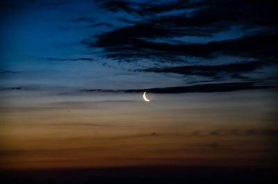 Low angle view of moon in sky at sunset