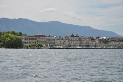 Buildings by sea against sky