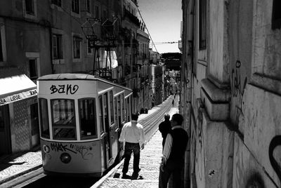 People standing on road along buildings