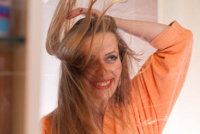 Smiling young woman with tousled hair at home