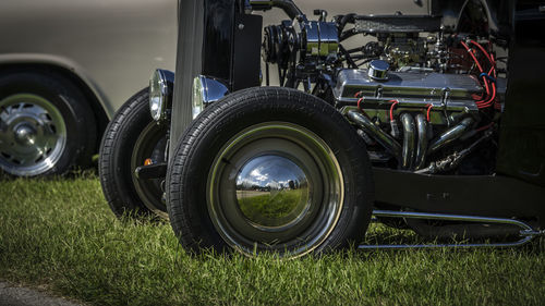 Close-up of vehicles parked on grassy field