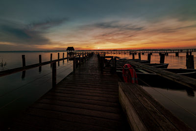 Pier over sea against sky during sunset