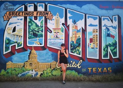 Woman standing on graffiti wall