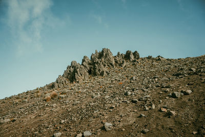 Low angle view of rocks on mountain against sky