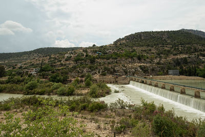 Scenic view of river with mountains in background