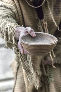 Midsection of man holding wooden bowl