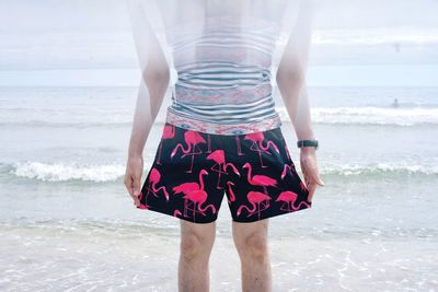 Double exposure of man standing on shore at beach