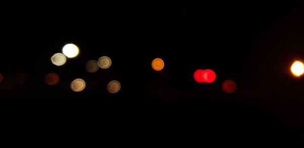 Defocused image of lights against sky at night