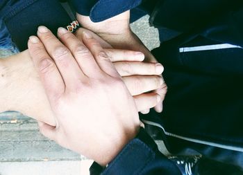 Cropped image of friends stacking hands