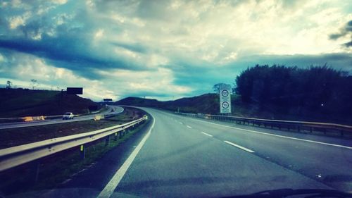 View of highway against cloudy sky