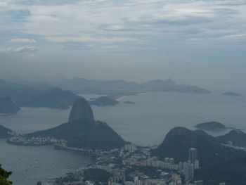 High angle view of city by sea against sky