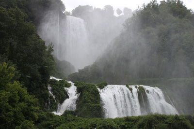 Low angle view of waterfall during foggy weather