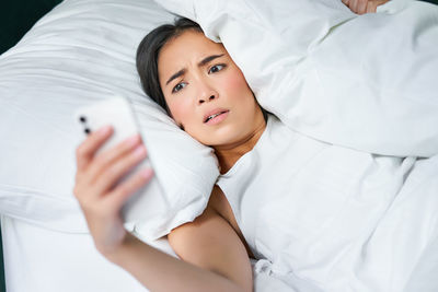 Portrait of young woman sleeping on bed at home