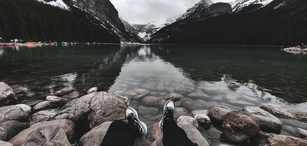 Reflection of rocks in lake against sky